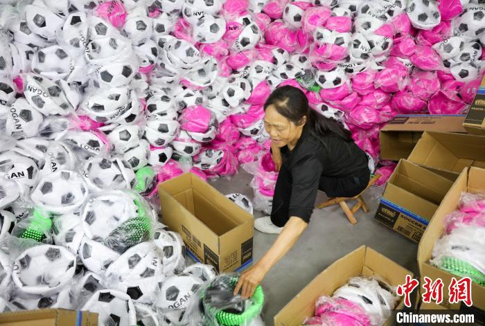 施秉县桃子湾工业园区内的一体育用品企业的员工正在将足球装箱。　磨桂宾 摄