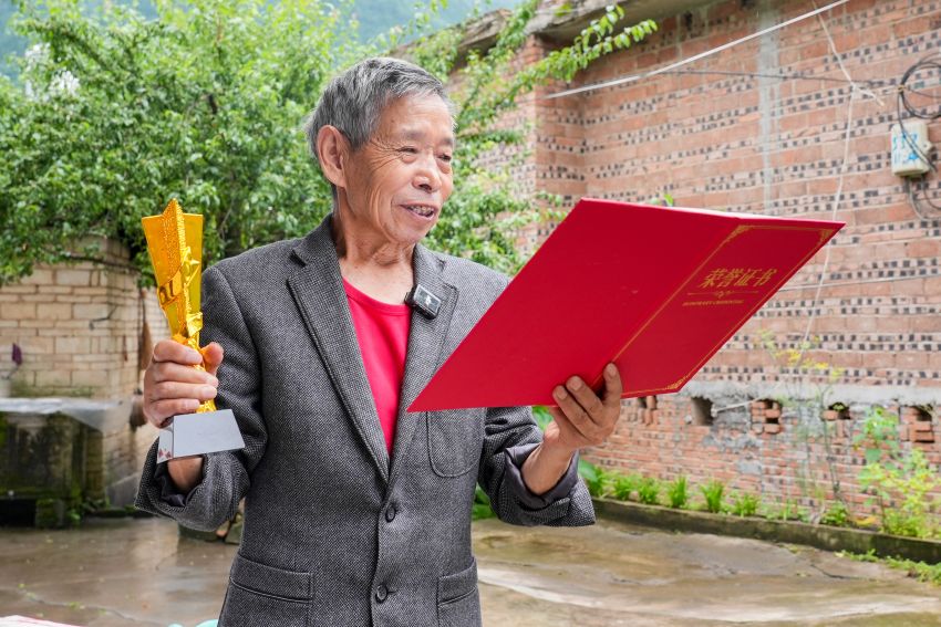 宋安炳展示获奖证书及奖杯 王洋摄 