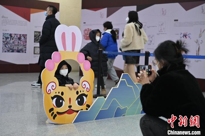 图为1月25日，甘肃省博物馆文物图片展区，家长正在给孩子拍照留念。　李亚龙 摄