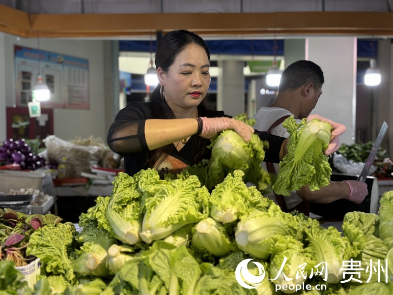 罗芬正在整理摊位上的蔬菜。人民网记者 高华摄