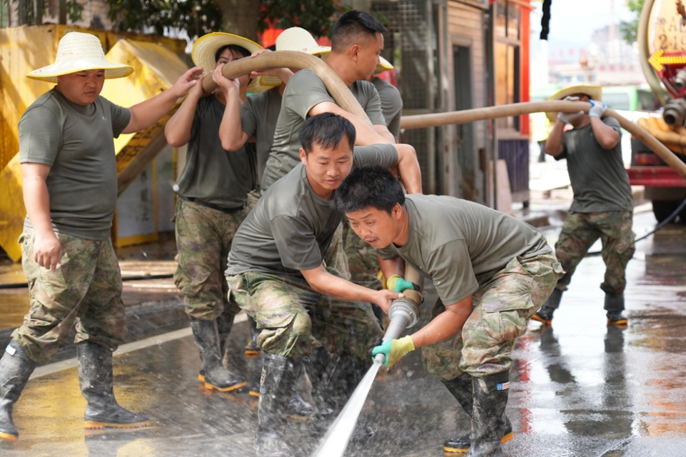 贵州丹寨:抢险救援一线上的“七一”建党节_fororder_7月1日,在贵州省榕江县“村超”球场,驰援抢险救灾一线的丹寨县救援队伍在清洗街道。 (1).JPG