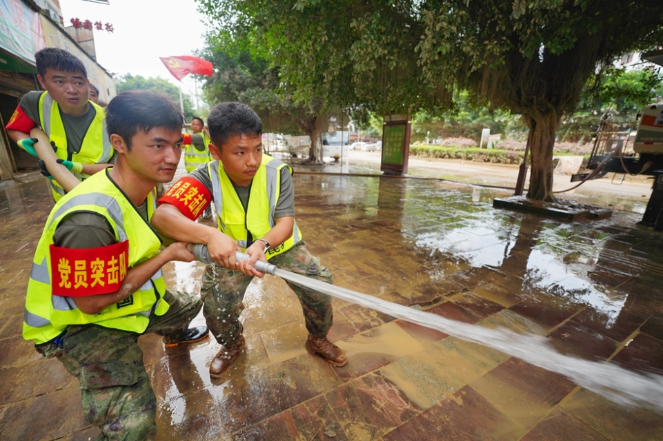 贵州丹寨:抢险救援一线上的“七一”建党节_fororder_6月30日,在贵州省榕江县城,来自丹寨县的党员驰援队员在冲洗街道。 (1).JPG