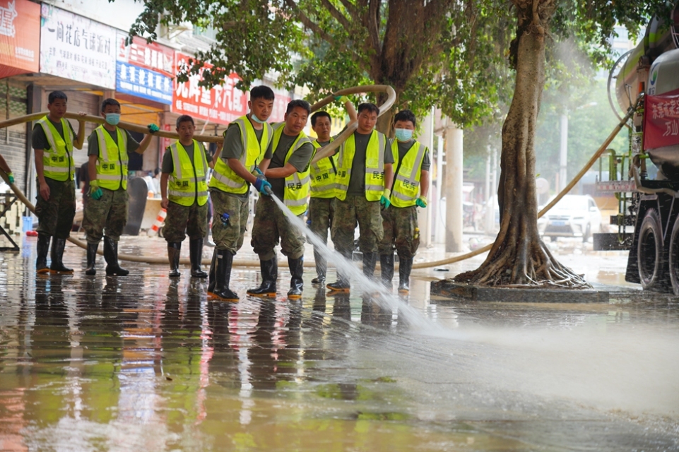 贵州丹寨:抢险救援一线上的“七一”建党节_fororder_6月30日,在贵州省榕江县城,来自丹寨县的驰援队员在冲洗街道。.JPG