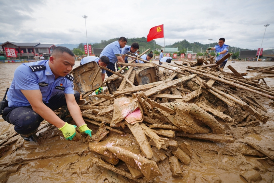 贵州丹寨:抢险救援一线上的“七一”建党节_fororder_6月29日,在贵州省榕江县“村超”球场,来自丹寨县的驰援队员在清理淤泥和杂物。 (1).JPG