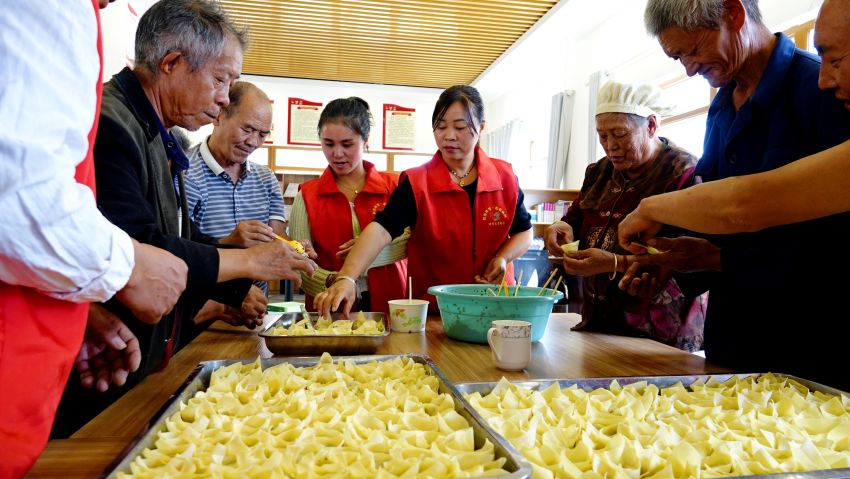 2025年9月28日，七星关区柏杨林街道幸福社区开展“月圆国庆，饺暖人心”主题活动，现场，老人和志愿者们正在包饺皮。（刘荣江 摄） 