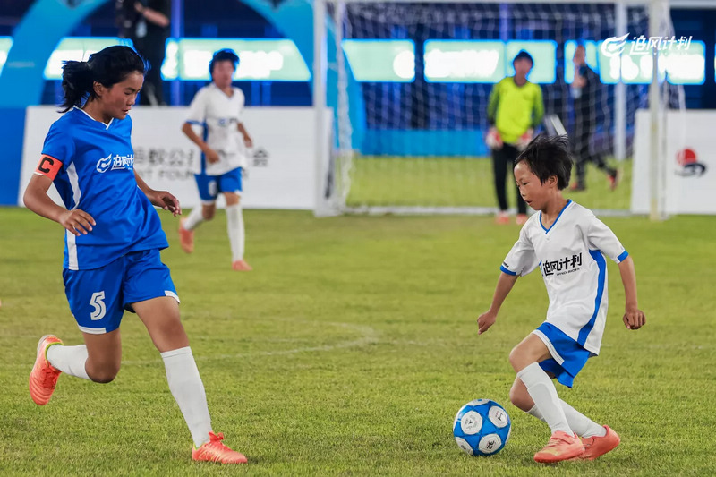 身穿白色球衣的元宝女足驰骋在赛场上。图片由元宝同心实验学校提供
