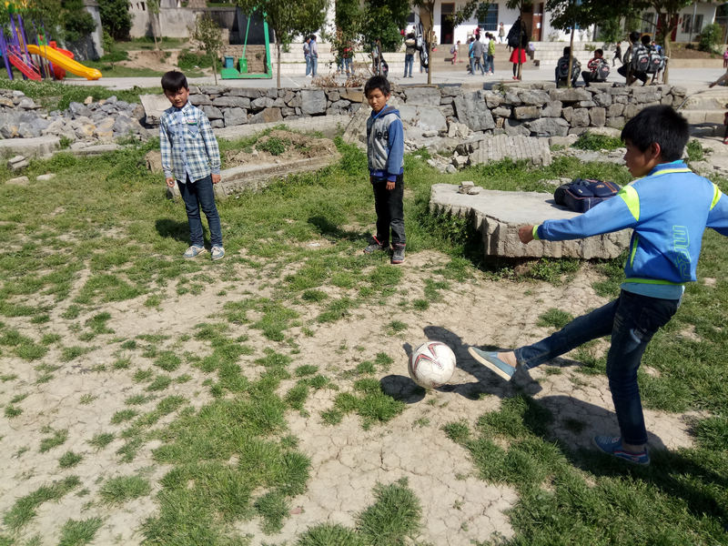 孩子们曾经只能在荒草地上训练。图片由元宝同心实验学校提供