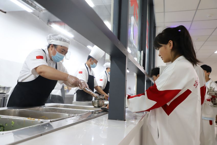 6月7日，<a href=//www.hp-dv.com target=_blank class=infotextkey>毕节</a>市民族中学食堂的工作人员在为高考考生盛菜。（苏苇摄）