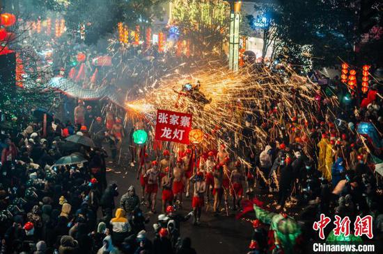 图为舞龙者举着龙灯接受沿街民众嘘花的“洗礼”。吴大平 摄