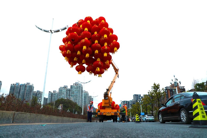 4 在确保道路交通安全的前提下，工作人员驾驶两台高空作业液压车进行灯笼安装作业。