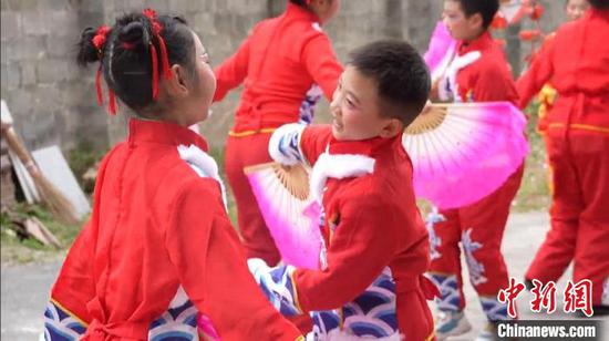 苏瑞翔、苏佳成两兄弟和女同学一手扬帕、一手舞扇,为农户“跳花灯”送祝福。谢小龙 摄 苏瑞翔、苏佳成两兄弟和女同学一手扬帕、一手舞扇,为农户“跳花灯”送祝福。谢小龙 摄