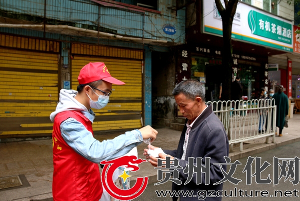 2022年9月13日，纳雍县城，志愿者在向未戴口罩的市民发放口罩，并要求戴上 。