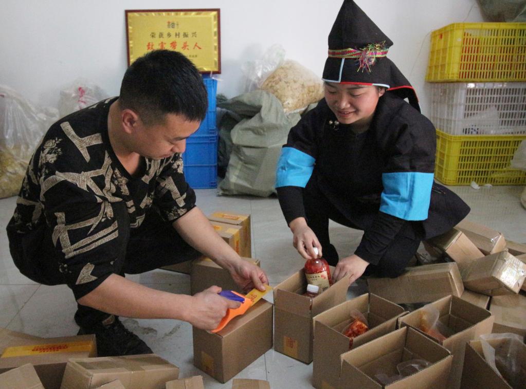3月4日,榕江县的“直播达人”王启红(右)在贵州榕江两汪乡两汪村打包产品。(陶明霞 摄)