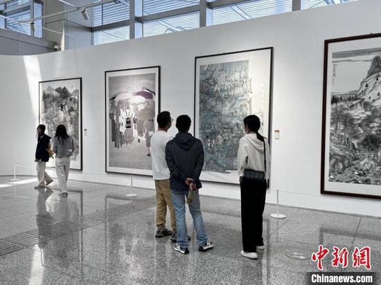 游客正在欣赏画作。徐立红 摄 游客正在欣赏画作。徐立红 摄