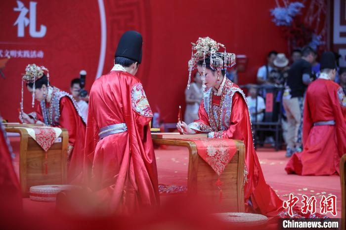 参加中华婚礼的新人在进行“共书婚贴”仪式。 瞿宏伦 摄 参加中华婚礼的新人在进行“共书婚贴”仪式。 瞿宏伦 摄