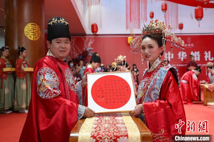 参加中华婚礼的一对新人在展示书写的婚贴。 瞿宏伦 摄 参加中华婚礼的一对新人在展示书写的婚贴。 瞿宏伦 摄