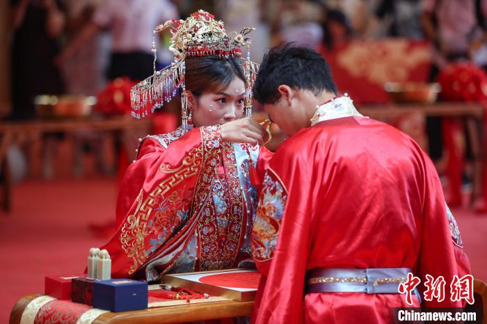 参加中华婚礼的一对新人在进行“解缨结发”仪式。 瞿宏伦 摄 参加中华婚礼的一对新人在进行“解缨结发”仪式。 瞿宏伦 摄