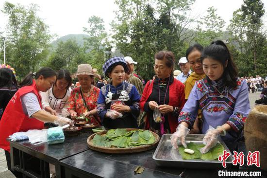 图为贵州册亨大寨村布依群众欢庆传统节日“三月三”,外地游客品尝美食。叶方杰 摄 图为贵州册亨大寨村布依群众欢庆传统节日“三月三”,外地游客品尝美食。叶方杰 摄