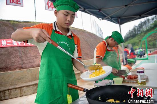 5月9日,在贵州省从江县城关第三小学,参赛选手在合作炒制西红柿炒蛋。吴德军 摄 5月9日,在贵州省从江县城关第三小学,参赛选手在合作炒制西红柿炒蛋。吴德军 摄