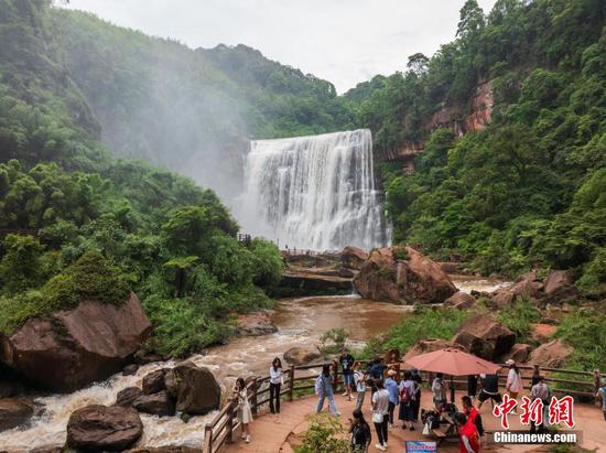 5月27日,游客在赤水丹霞旅游区·赤水大瀑布前游玩拍照。 5月27日,游客在赤水丹霞旅游区·赤水大瀑布前游玩拍照。