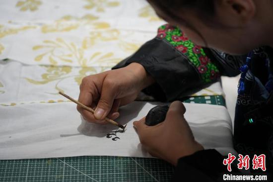 6月19日,王秋雨在织金县平远古镇的依文织金数字化展厅制作蜡染。周燕玲 摄 6月19日,王秋雨在织金县平远古镇的依文织金数字化展厅制作蜡染。周燕玲 摄